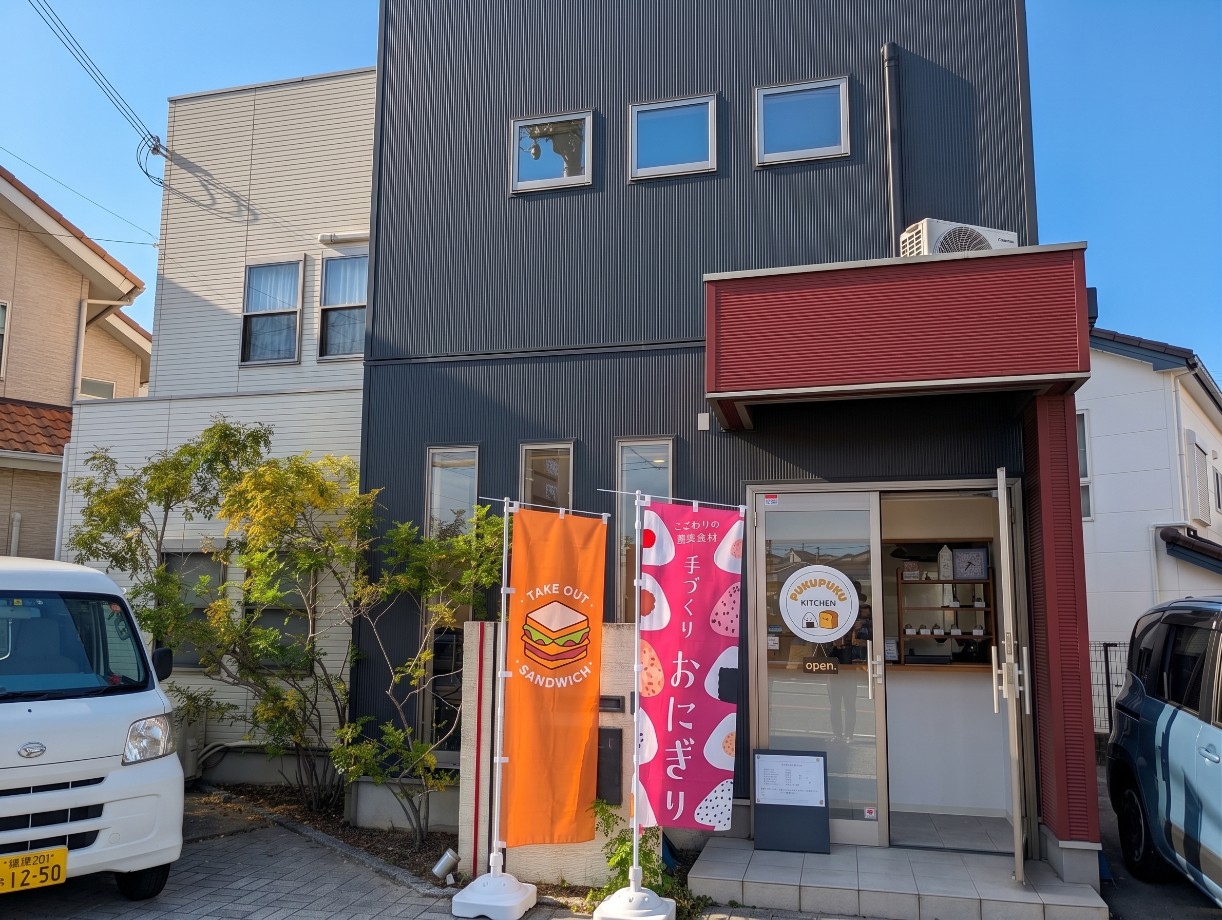 熊取 【PUKUPUKU KITCHEN】の外観。テイクアウトサンドイッチと手づくりおにぎりののぼりが立つ